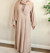 Load image into Gallery viewer, Image of a model wearing our classic taupe open abaya. The abaya can be styled open or closed, offering versatility for any occasion. It&#39;s perfect for all seasons and can be easily dressed up or down for a chic look. 
