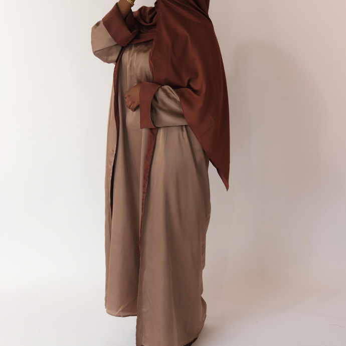 Women's reversible 2-in-1 abaya 3-piece set in brown. Includes an outer abaya, underdress, and matching hijab in a darker brown shade. Versatile modest wear, perfect for any occasion. High-quality satin fabric, elegant design, and modest fashion essentials. One set, multiple ways to style.