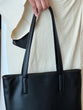 Load image into Gallery viewer, Model holding black leather tote bag
